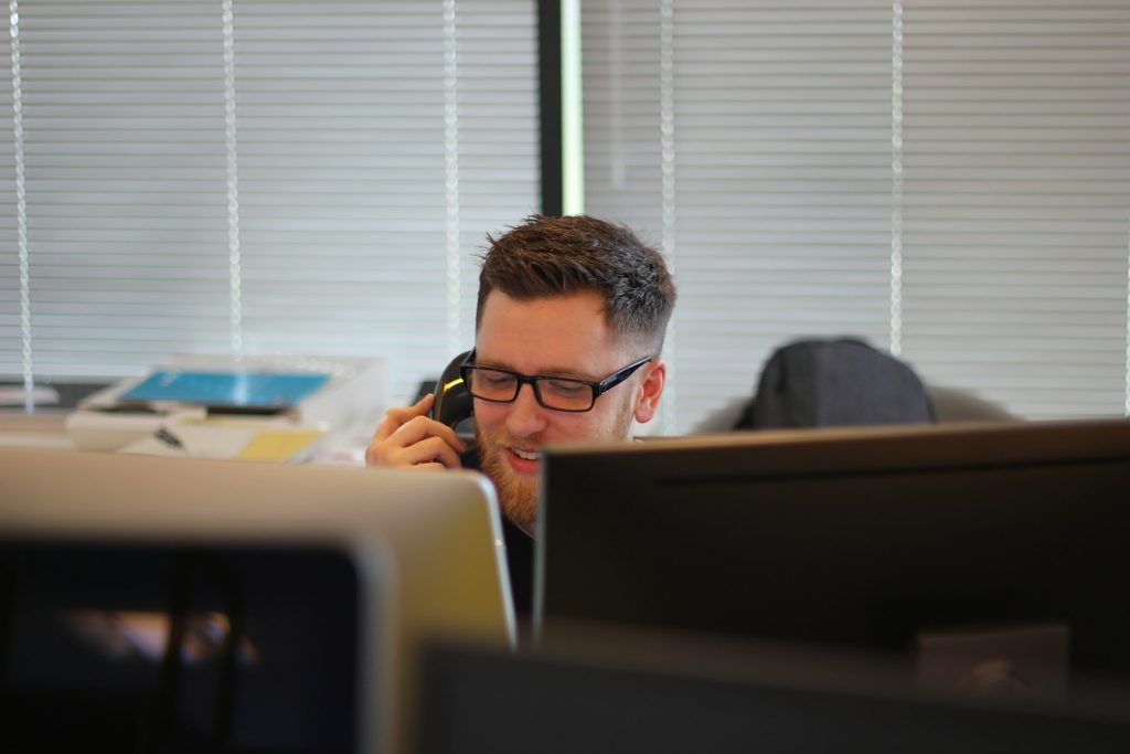 A man on a desk phone in an office