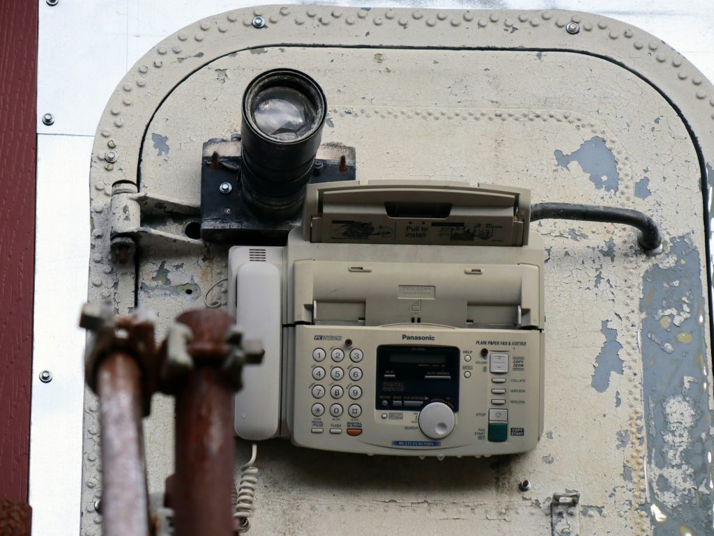 Fax machine and phone on an old wall